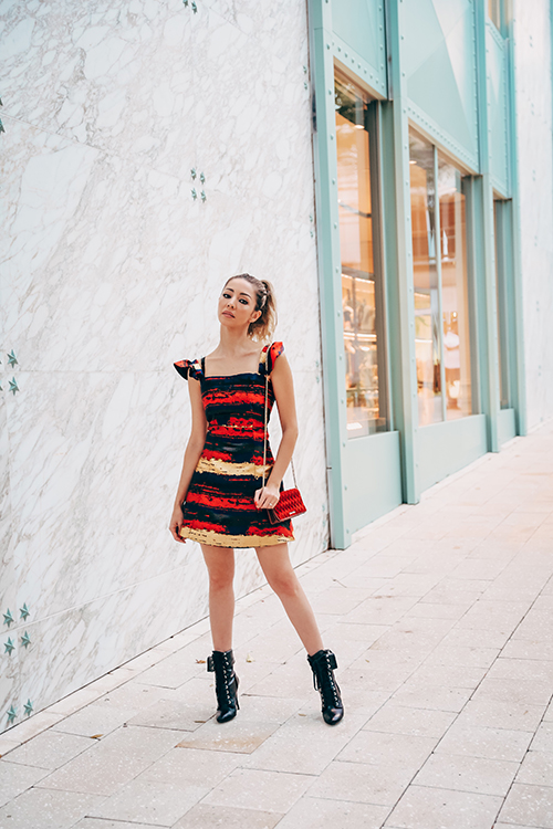 Karen Huggins wearing a colorful striped Three Floor dress and black boots