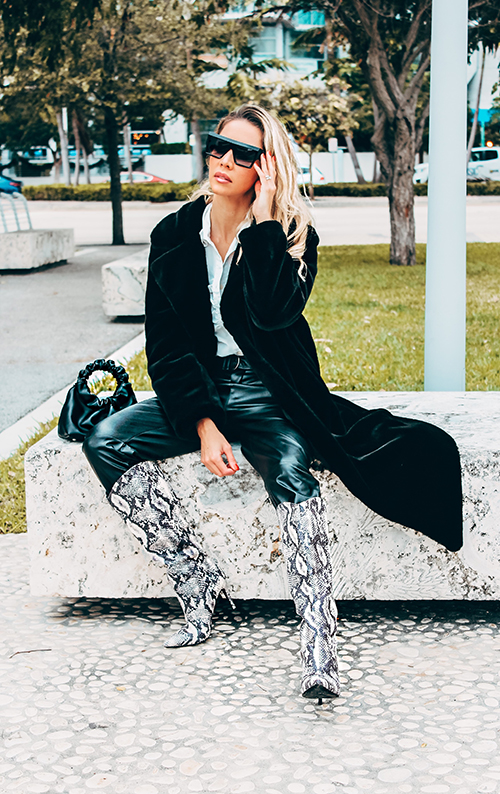 Karen Huggins wearing a black Verafied coat with a handbag