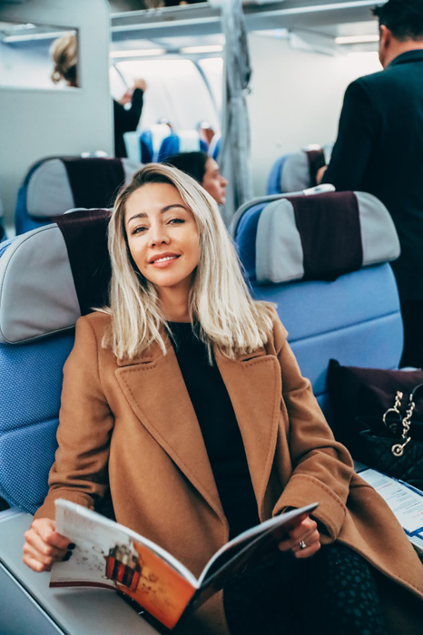 Traveler seated in the Corsair Premium cabin holding a magazine