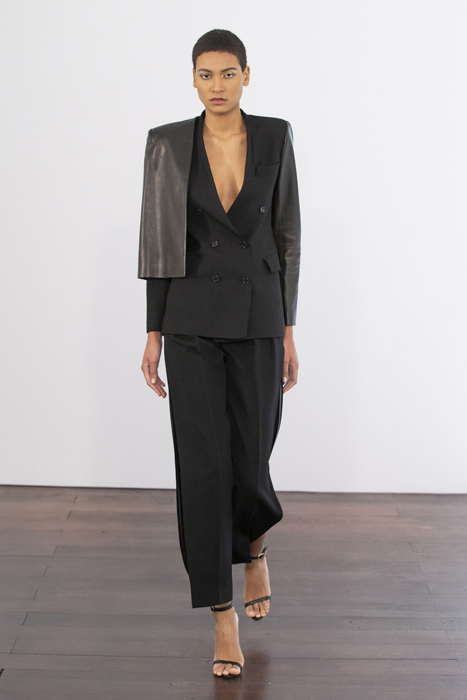 Guy Laroche model wearing a black tailored suit with a draped shoulder detail