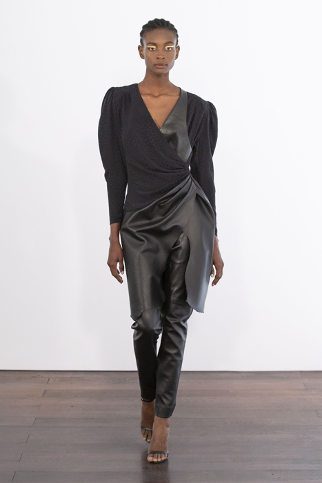 Guy Laroche model wearing a dark asymmetric jacket and trousers