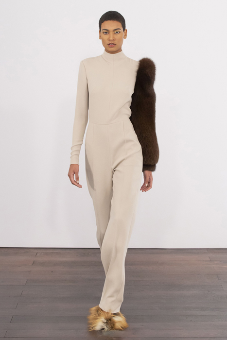 Guy Laroche model wearing a beige outfit with a dark contrasting sleeve