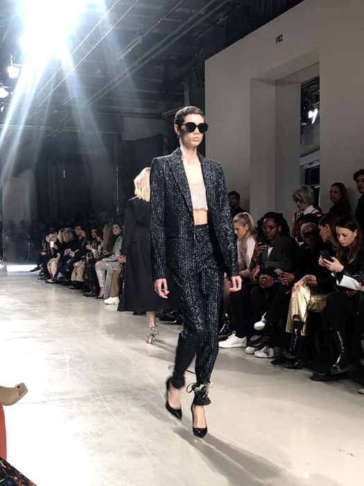Ingie Paris model in a dark tailored outfit and sunglasses