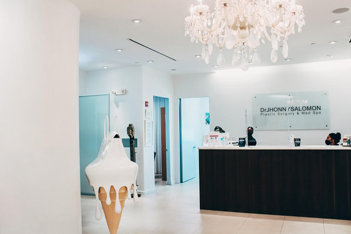 Reception area at Dr. Jhonny Salomon’s practice, with a chandelier and contemporary sculpture