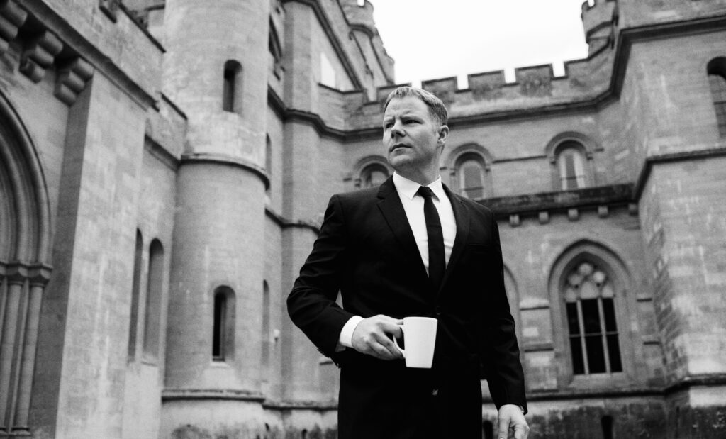 Chris Lavoie standing outside a historic French château during an international television production in France