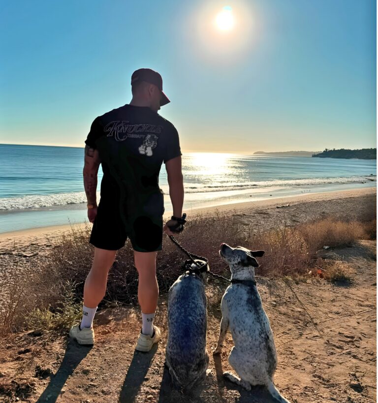 Noah Neiman of The Pack walking with his dogs by the beach