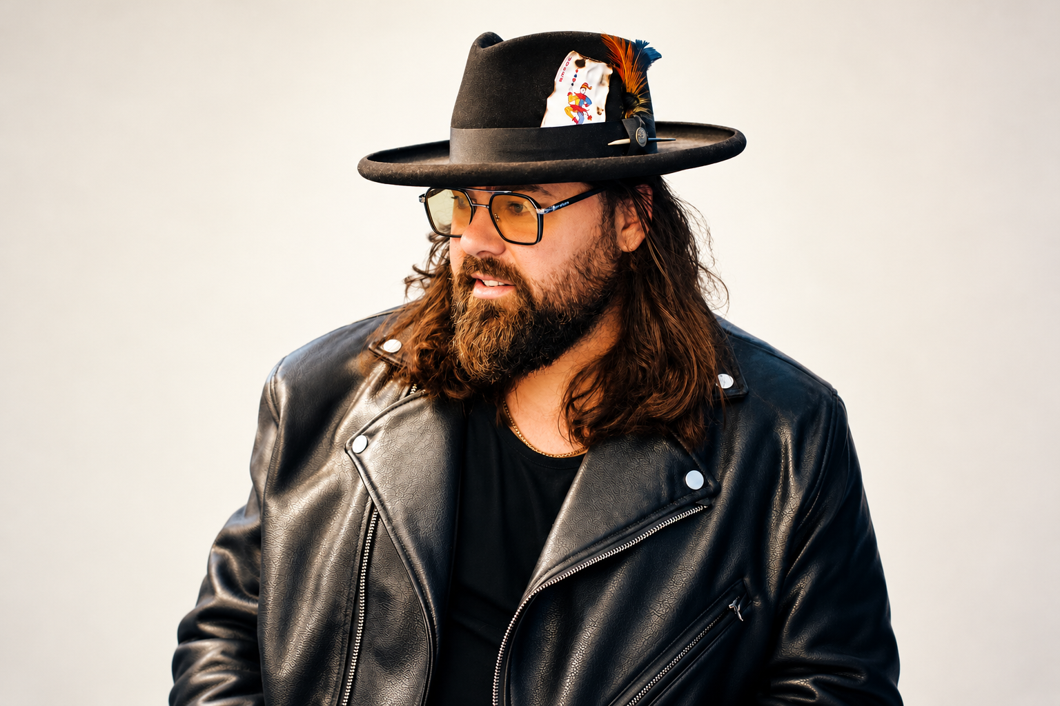 Mario Ramil wearing amber glasses, a black hat, and a leather jacket.