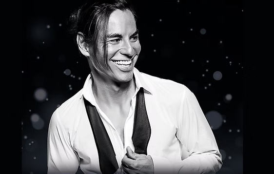 Julio Iglesias Jr. performs with his band beneath blue lights during the Julio Iglesias Experience.
