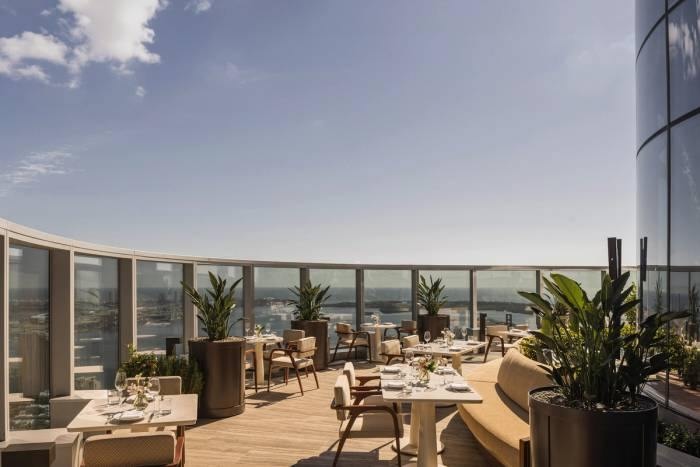 Seia’s rooftop dining terrace with set tables, tropical plants, and views over Brickell.